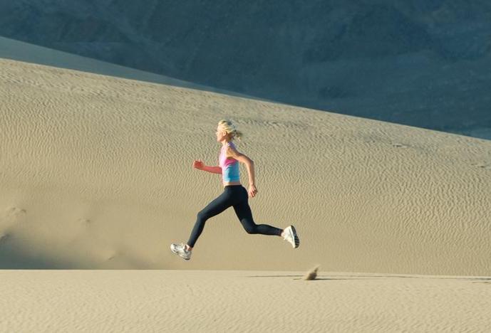 woman running on sand dunes