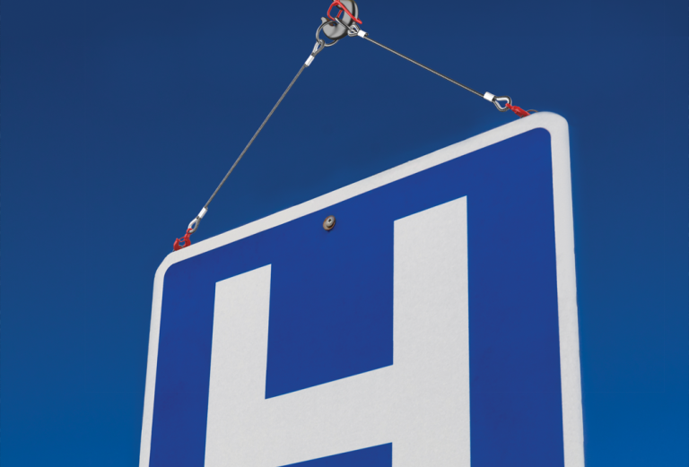 Large hospital sign being held up by a crane