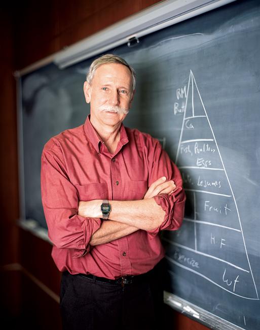 man in red button up shirt in front of chalk board