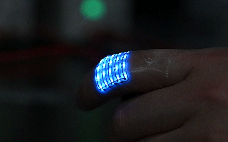 A GIF shows a finger moving with a small, flexible blue light LED device attached to it.