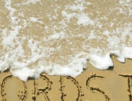 waves breaking on shore over words written in the sand