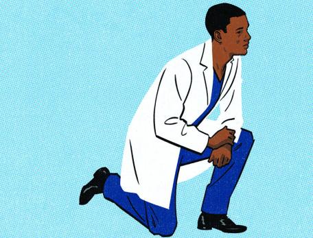 young man in a white coat taking a knee