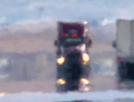 semi trucks pass on a highway that simmers with heat