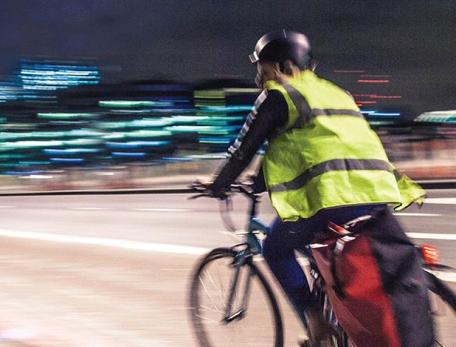 bicyclist riding over Charles River bridge from Cambridge to Boston at night