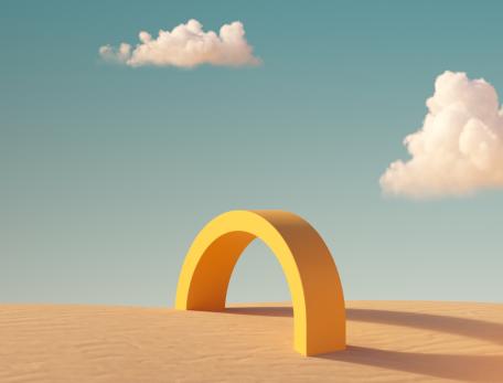 abstract scene featuring a small yellow arc on a desert scape with puffy clouds in a blue sky