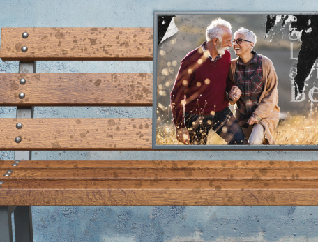 detail of image showing an empty park bench that has a weathered ad for assisted or independent living for older adults