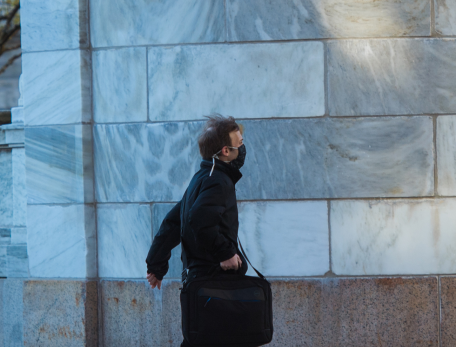 man carrying briefcase and wearing a face mask on HMS campus