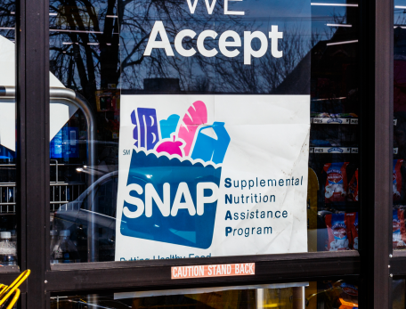 sign in a grocery story window indicating SNAP vouchers are accepted