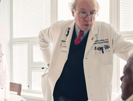 Douglas Kelling with young physician at bedside