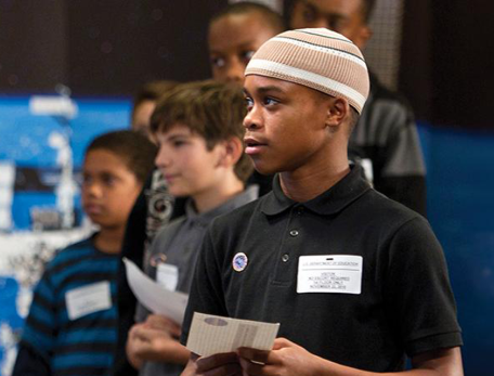 Schoolchildren at an event at the U.S. Department of Education in Washington, D.C., wait for their chance to question astronauts.