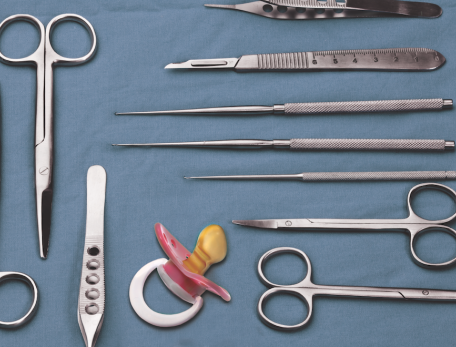 pacifier on a blue table with surgical instruments