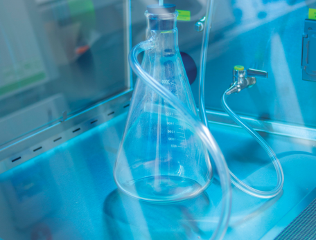 beaker in a lab enclosure with tubes coming out of it