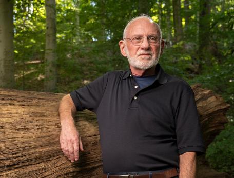 richard ferber leaning on a fallen tree trunk in the forest