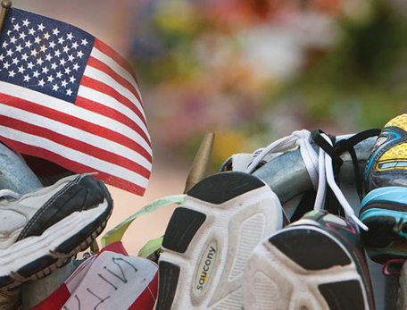 A collection of running shoes with a small American flag tucked inside of one