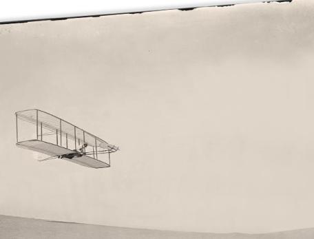 old photograph of a early airplane flying