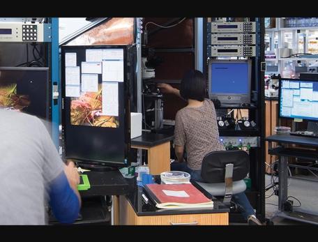 scientists work in a lab space filled with various computers and instruments