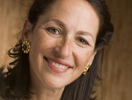 woman smiling in front of a brown wall