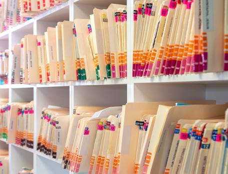 A shelf covered with folders holding medical records