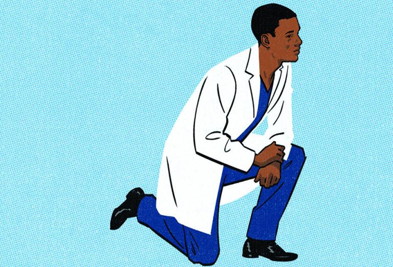 young man in a white coat taking a knee