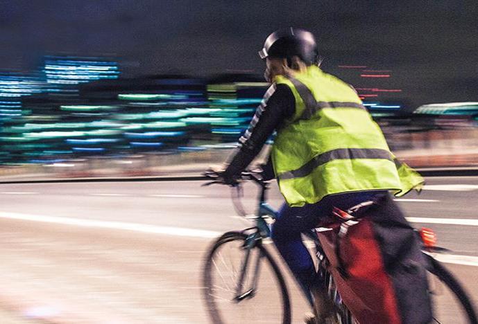 bicyclist riding over Charles River bridge from Cambridge to Boston at night