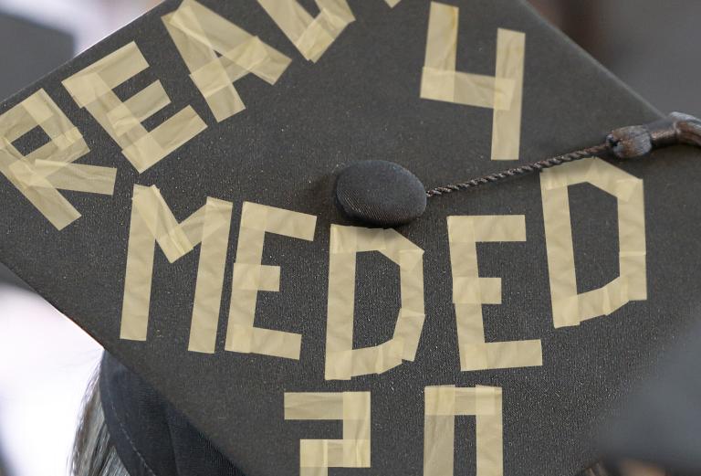 Top view of a morterboard with masking tape forming words: ready for med ed