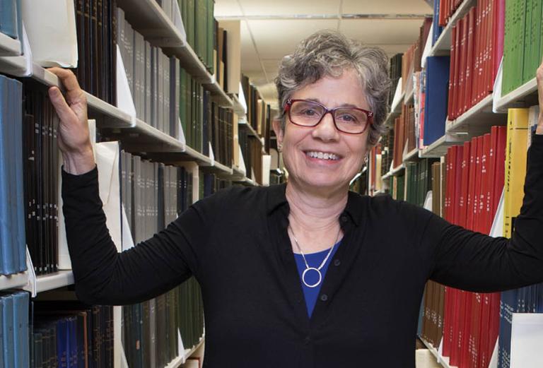 Long shot of Deborah Zarin in aisle between book shelves