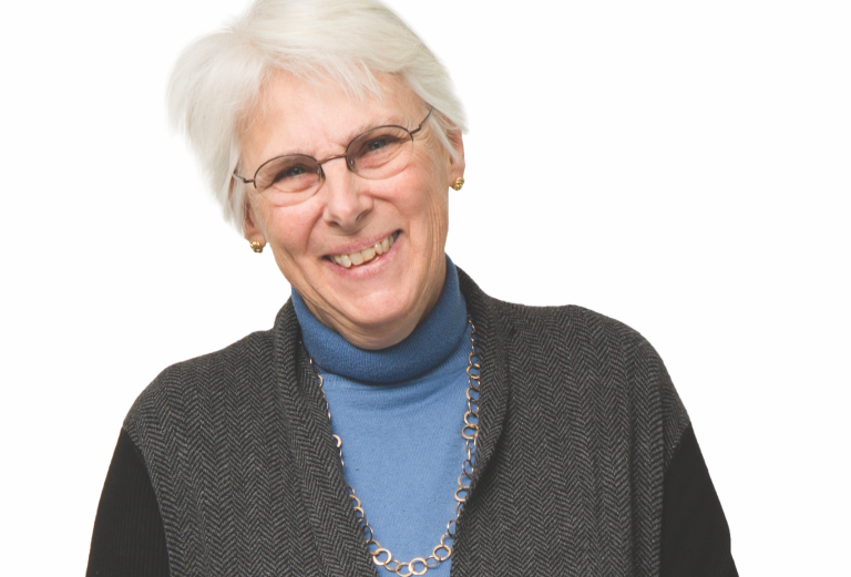 woman in blue turtleneck and grey sweater on a white background