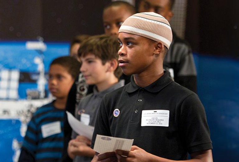 Schoolchildren at an event at the U.S. Department of Education in Washington, D.C., wait for their chance to question astronauts.