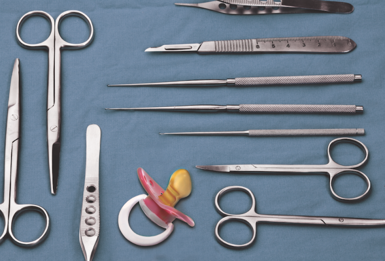 pacifier on a blue table with surgical instruments