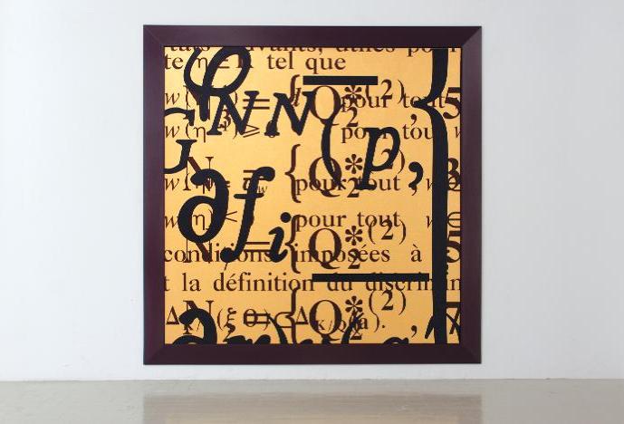 a yellow canvas in a black frame on a white wall with chaotic black text on the canvas