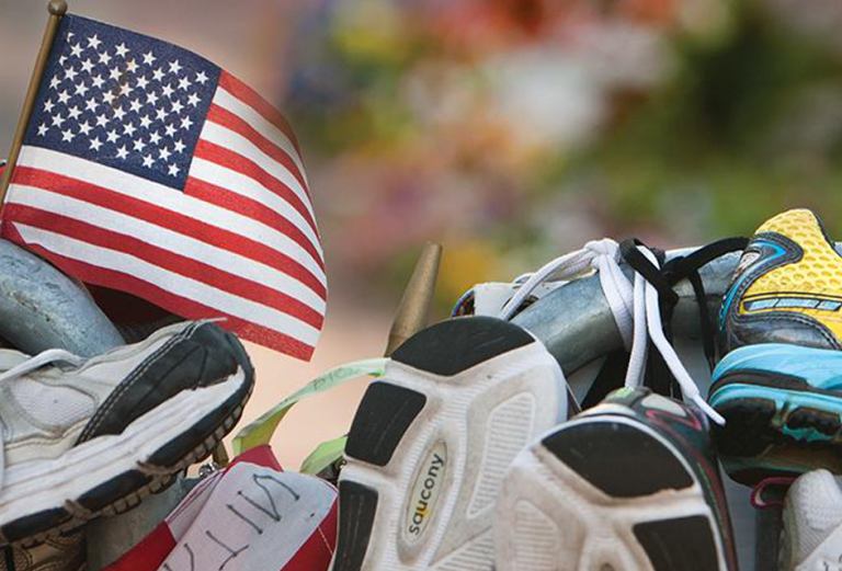 A collection of running shoes with a small American flag tucked inside of one