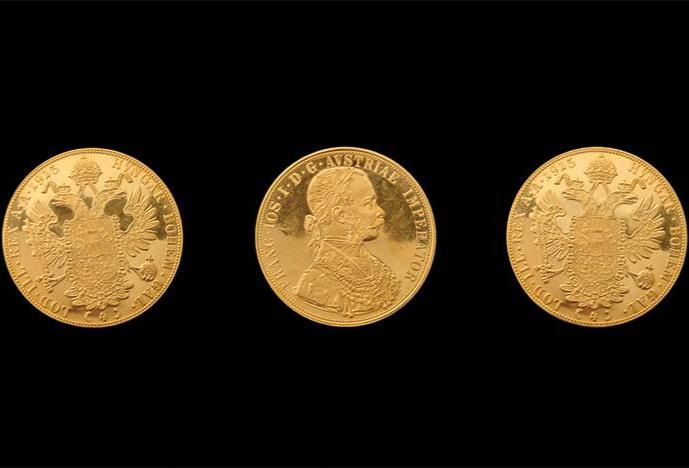 three golden coins on a black background