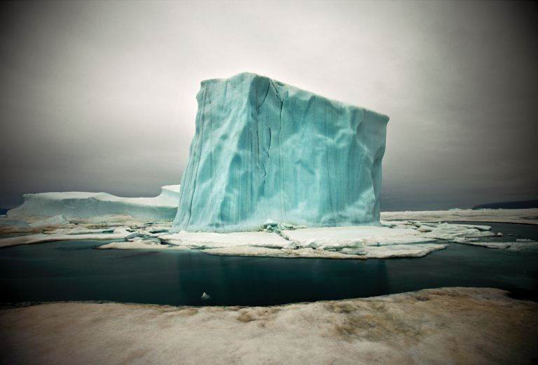 Lone iceberg eerily lit with blueish cast