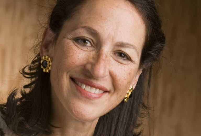 woman smiling in front of a brown wall