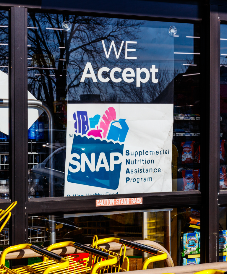 sign in a grocery story window indicating SNAP vouchers are accepted