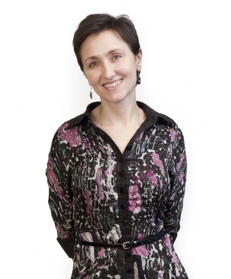 woman with short dark hair and a flower dress against a white backgroun