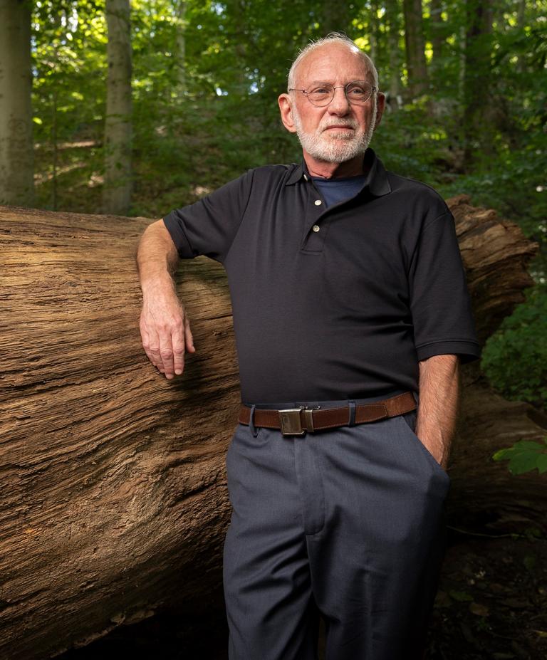 richard ferber leaning on a fallen tree trunk in the forest