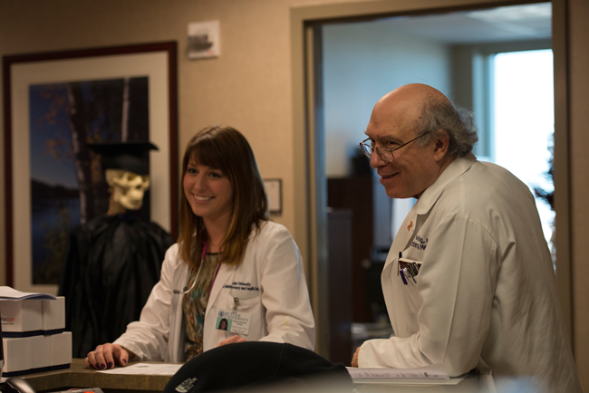 Douglas Kelling with doctor-in-training talking with clinic coworkers