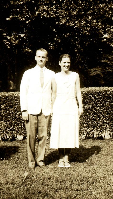 Perry and gretta Baird stand outdoors next to one another wearing summer whites, 1933