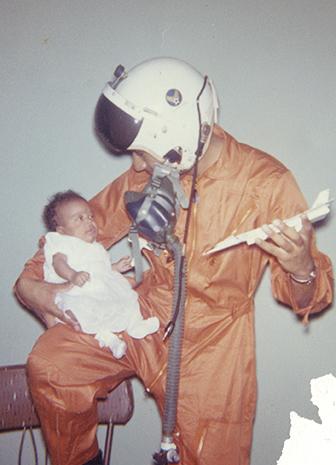 Pilot Fountain wearing flight suit and holding baby daughter, Tamara