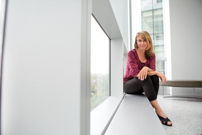 woman in purple shirt sitting on bench by window