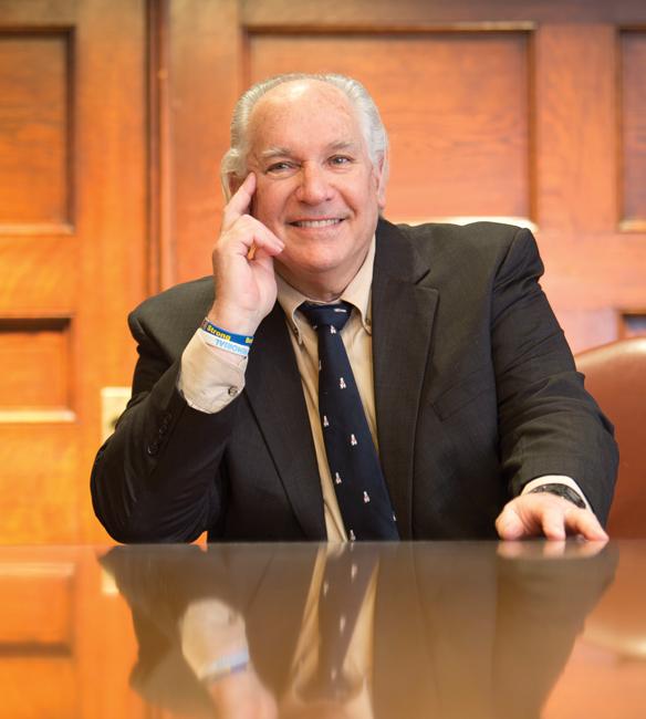 man in suit and tie sitting at a brown wood table