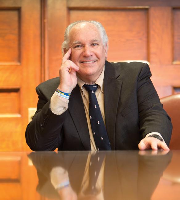 man in suit and tie sitting at a brown wood table