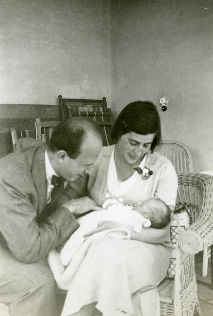 man and woman looking at baby in the woman's arms