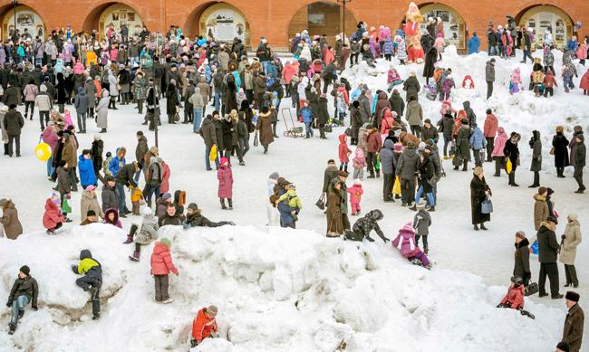 photo of a crowd of children and parents playing in snow
