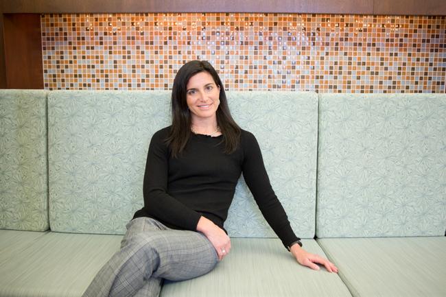 woman in black shirt and grey pants sitting on green couch