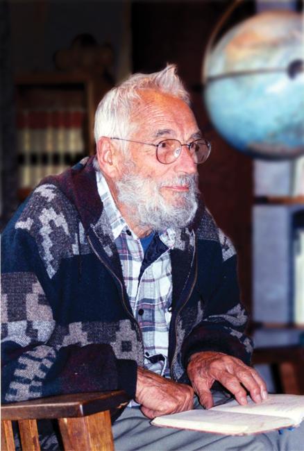 man with white hair and beard sitting in a chair