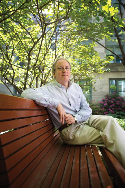 man in dress shirt and khakis sitting on park bench