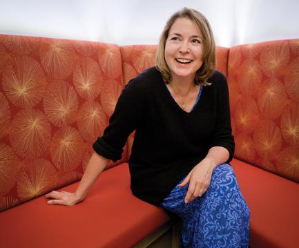 woman in black sweater sitting on red couch