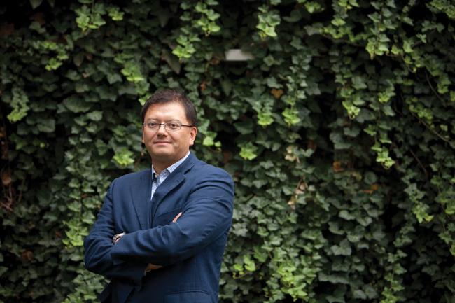 takeao hensch standing with arms folded in front of a green ivy colored wall